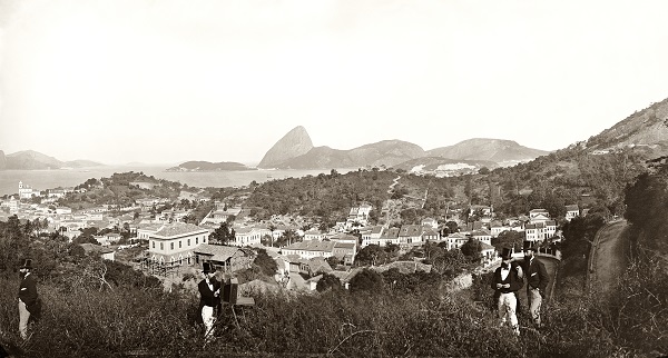 Paisagem de Santa Teresa, por Marc Ferrez (c. 1885). Aqui, mais curioso do que a paisagem (com a Rua Cândido Mendes, que sobe da Glória, no canto inferior direito) é a dupla aparição do próprio Ferrez, de calça mais clara, e de um amigo desconhecido na foto. A explicação é simples: a câmera era dotada de um mecanismo de varredura, que produzia uma imagem ao longo de vários minutos a partir de cliques sucessivos. Enquanto o equipamento fazia a panorâmica, os amigos mudavam de lugar diante da lente para aparecer duas vezes na mesma imagem Paisagem de Santa Teresa, por Marc Ferrez (c. 1885). Aqui, mais curioso do que a paisagem (com a Rua Cândido Mendes, que sobe da Glória, no canto inferior direito) é a dupla aparição do próprio Ferrez, de calça mais clara, e de um amigo desconhecido na foto. A explicação é simples: a câmera era dotada de um mecanismo de varredura, que produzia uma imagem ao longo de vários minutos a partir de cliques sucessivos. Enquanto o equipamento fazia a panorâmica, os amigos mudavam de lugar diante da lente para aparecer duas vezes na mesma imagem
