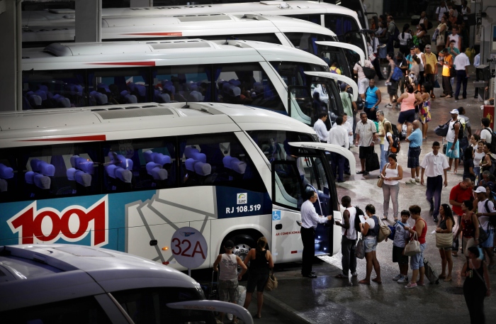 Garagem com ônibus e pessoas