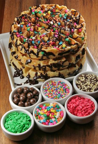 O waffle explosion (R$ 26,90) transforma o lanche em festa. A massa fofinha vemm acompanhada por diferentes opções de calda (chocolate preto, chocolate branco, entre outras) e diversos toppings (granulados, bolinhas brancas e pretas, estrelinhas, corações<br> O waffle explosion (R$ 26,90) transforma o lanche em festa. A massa fofinha vemm acompanhada por diferentes opções de calda (chocolate preto, chocolate branco, entre outras) e diversos toppings (granulados, bolinhas brancas e pretas, estrelinhas, corações<br>