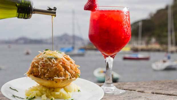 Caipirinha de morango e casquinha de siri na mureta voltada para a ba&iacute;a<br>