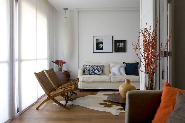 Tecidos coloridos, cortina branca leve e mesas laterais da designer C&acirc;ndida Interni d&atilde;o o ar sofisticado a esta bela sala.<br>