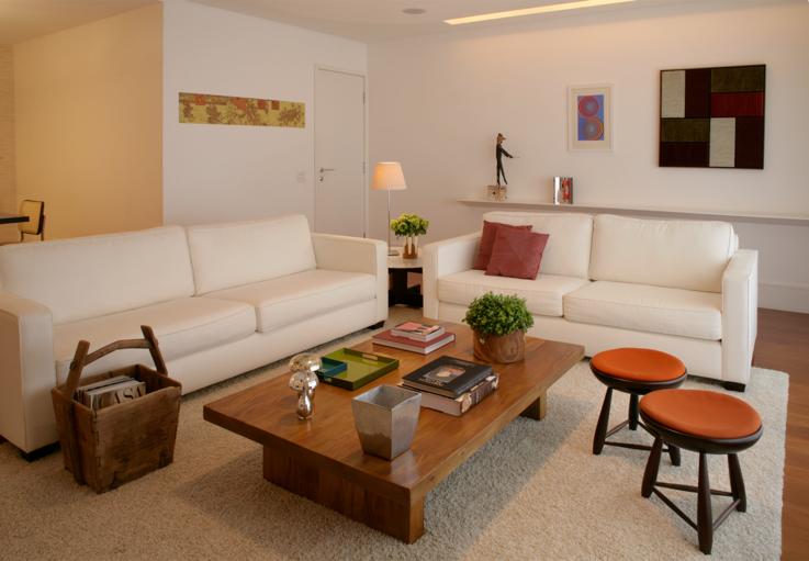 Banquinhos mocho do designer brasileiro Sérgio Rodrigues, tapete grande, tecidos coloridos, arranjo de flores naturais e quadro Conceição Rodrigues, da galeria HAP, compõem esta aconchegante sala de estar.<br> Banquinhos mocho do designer brasileiro Sérgio Rodrigues, tapete grande, tecidos coloridos, arranjo de flores naturais e quadro Conceição Rodrigues, da galeria HAP, compõem esta aconchegante sala de estar.<br>