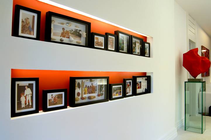 Nesta casa em S&atilde;o Conrado, a arquiteta Solange Medina criou nichos na parede do hall de entrada para abrigar porta-retratos exclusivos, elaborados de acordo com o tema de cada fotografia. Um porta-retratos decorado com conchas, por exemplo, foi criado par<br>