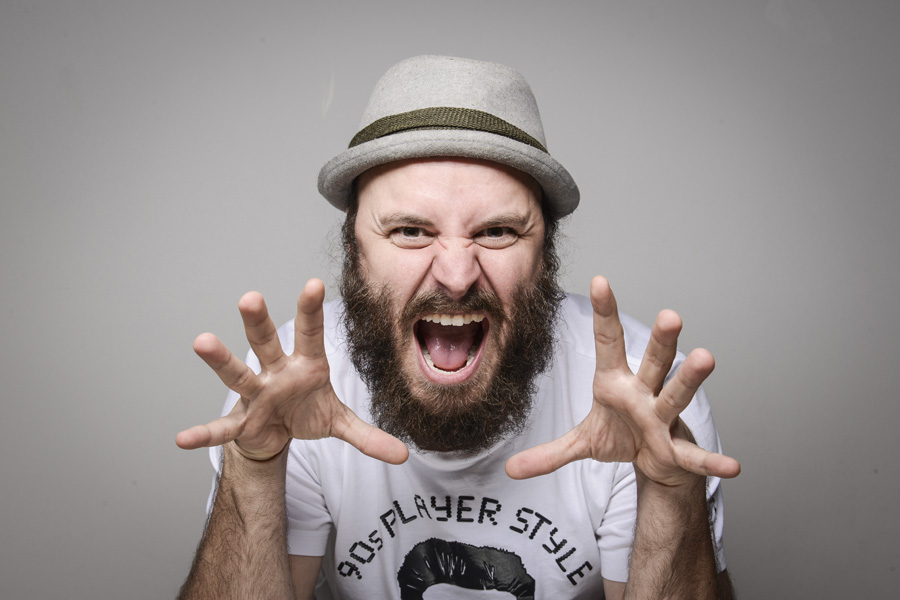 Paulinho Serra, de chapéu, com as mãos abertas ao lado do rosto