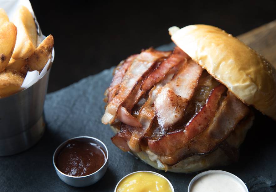 Joe’s bacon: blend bovino com fartas tiras de bacon, cheddar, cebola caramelada e maionese de bacon (R$ 28,00) Joe’s bacon: blend bovino com fartas tiras de bacon, cheddar, cebola caramelada e maionese de bacon (R$ 28,00)