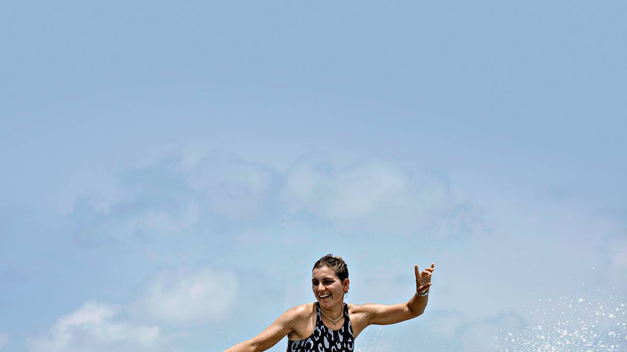 A imagem mostra a surfista Maya Gabeira fazendo uma manobra em uma onda no mar das Ilhas Maldivas