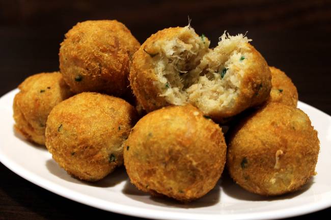 Corujão_Bolinho de bacalhau_6,50 por 5,00 A imagem mostra um monte de bolinhos de bacalhau, alguns deles abertos