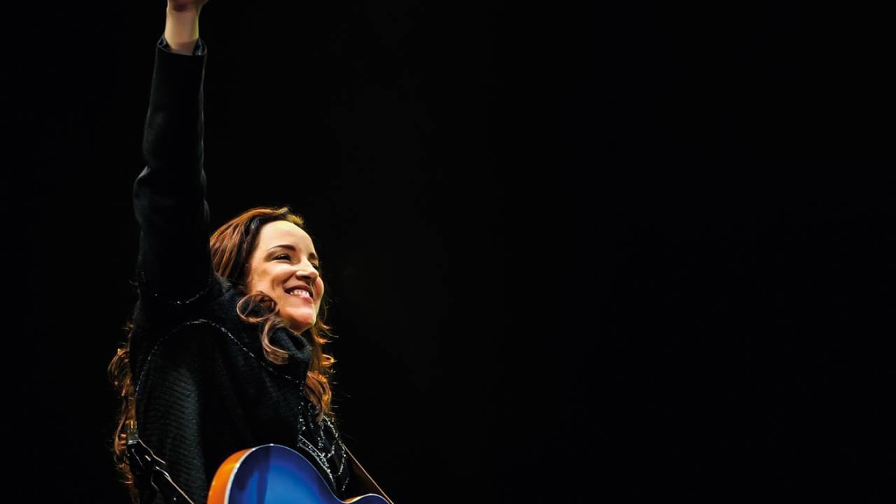 Cantora Ana Carolina no palco, segurando uma guitarra