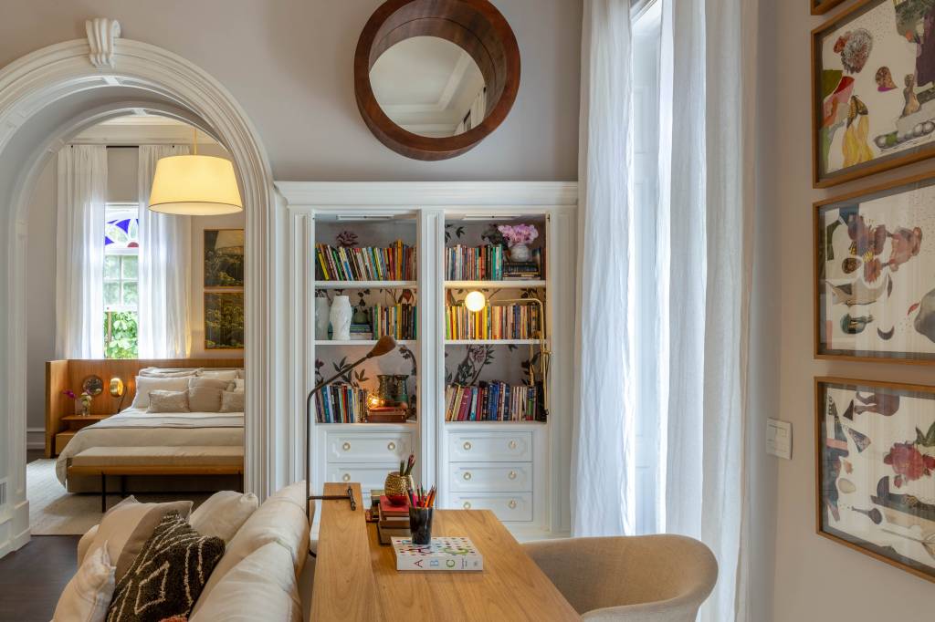 PAOLA RIBEIRO- SUITE DO CASAL–005 Quarto com prateleira com livros, escrivaninha, sofá e cama ao fundo