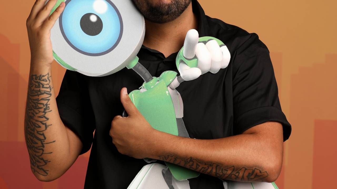 Projota segurando o robozinho mascote do BBB