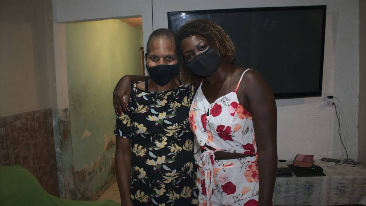 A imagem mostra Deise do Tombo abraçada a Paula, dona da casa onde ela caiu (o vídeo viralizou na internet)