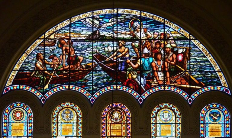 Batalha Das Canoas – Uruçumirim – Praia do Flamengo – 20/1/1567 – Estácio De Sá Expulsa da Baía Guanabara os Calvinistas Franceses – São Sebastião Aparece Lutando ao seu Lado. Vitral do Santuário Basílica de São Sebastião Frades Capuchinhos, Tijuca. César Formenti, 1931