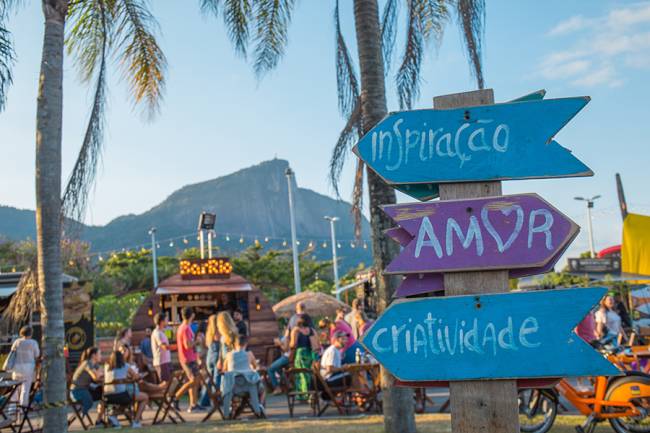 Babilônia Feira Hype montada na Lagoa, com uma placa em primeiro plano mostrando as palavras inspiração, amor e criatividade