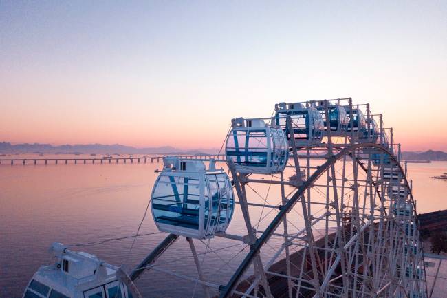 Visão da parte de cima da roda gigante Rio Star, com o pôr do sol na baía de guanabara ao fundo
