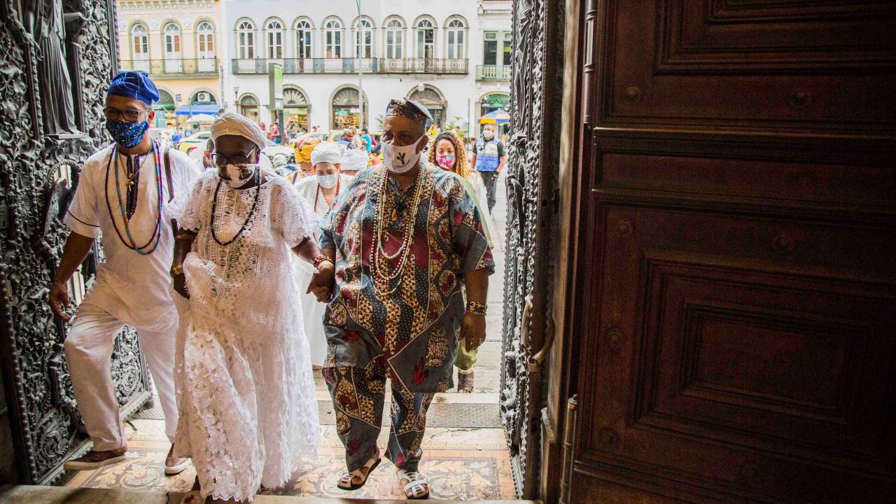 Mãe de Santo, acompanhada de um homem em trajes africanos, entrando no Museu da República