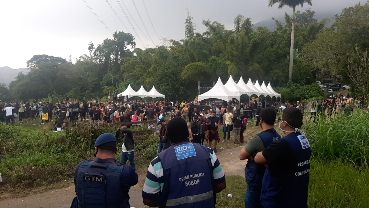 Agentes de fiscalização observam o público aglomerado sair debaixo das tendas da festa clandestina