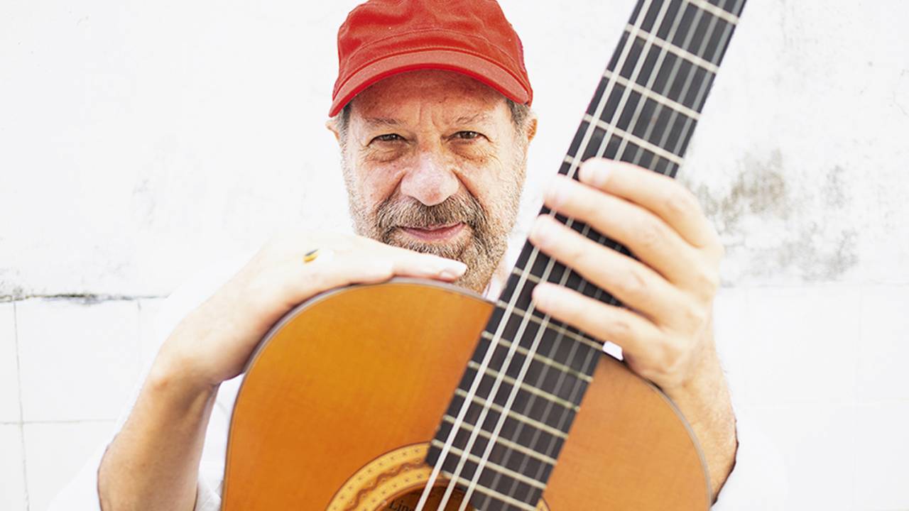 João Bosco segurando um violão na frente do corpo