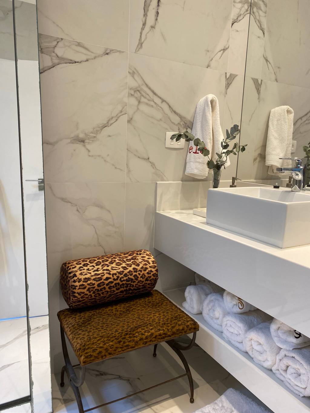 Animal print A imagem mostra um banheiro com banco de oncinha
