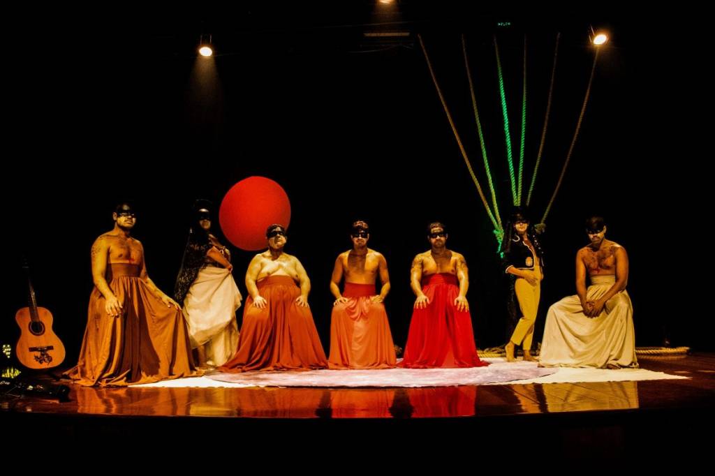 Proibido Vários atores vestidos de vermelho em um palco