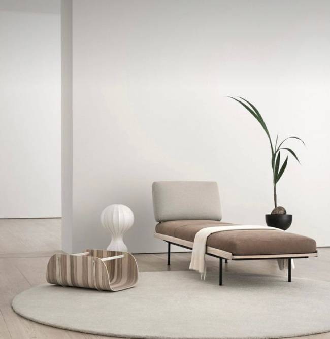 Estilo escandinavo A imagem mostra uma sala com um vaso de planta, tapete e poltrona