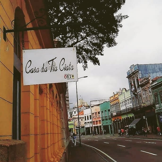 55786405_2250685821914271_3321719116791808_n Foto mostra uma placa escrita Casa da Tia Ciata com uma construção de cor amarela ao fundo