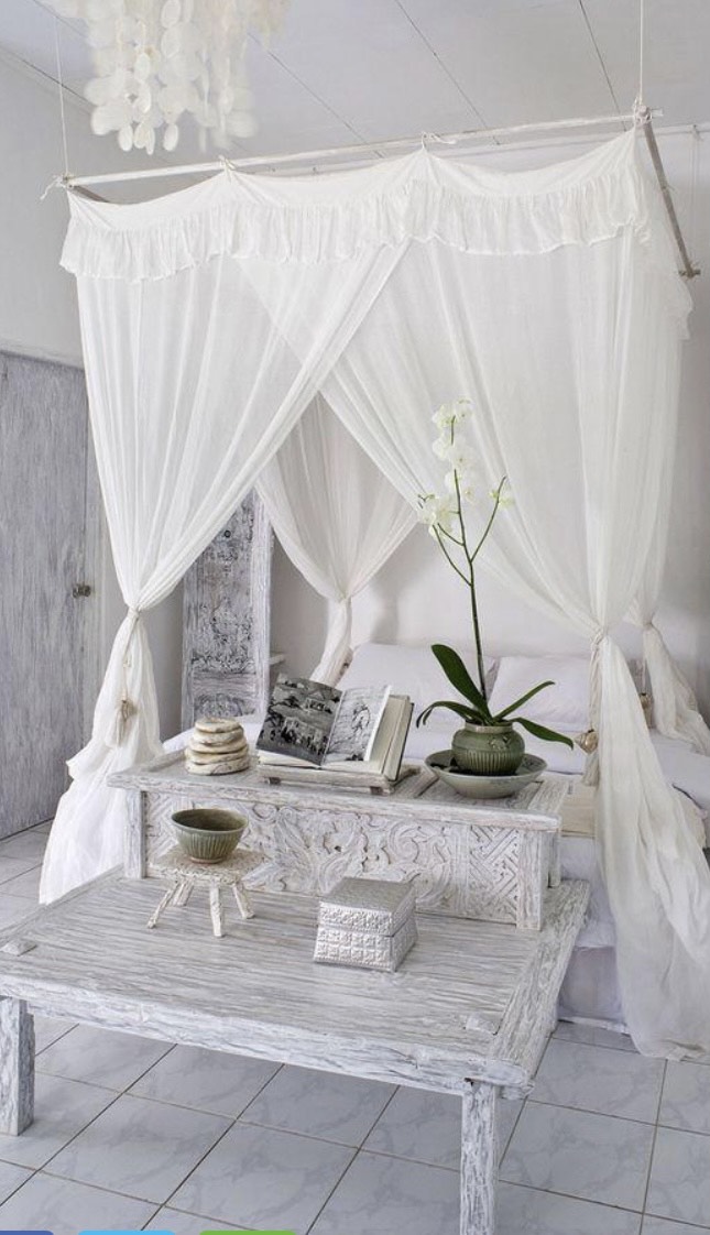 Cama com dossel A imagem mostra um quarto todo branco, cama com dossel e tecido branco