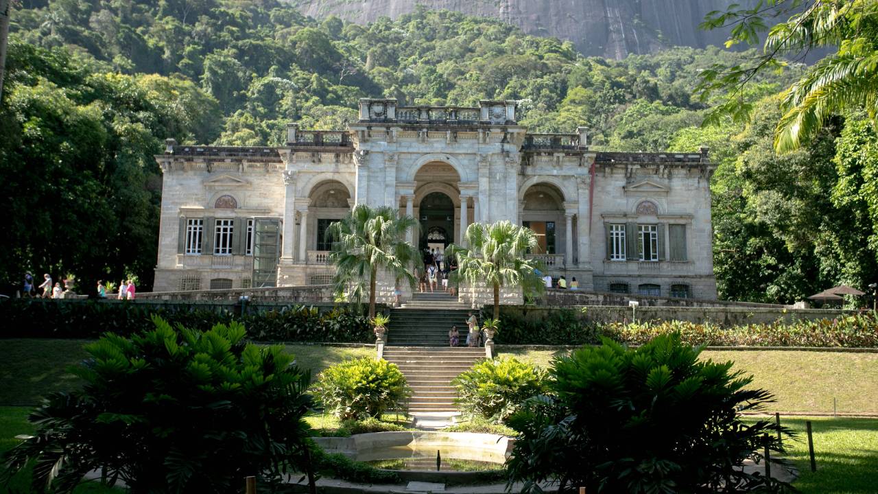 Foto da fachada e parte do jardim do palacete do Parque Lage