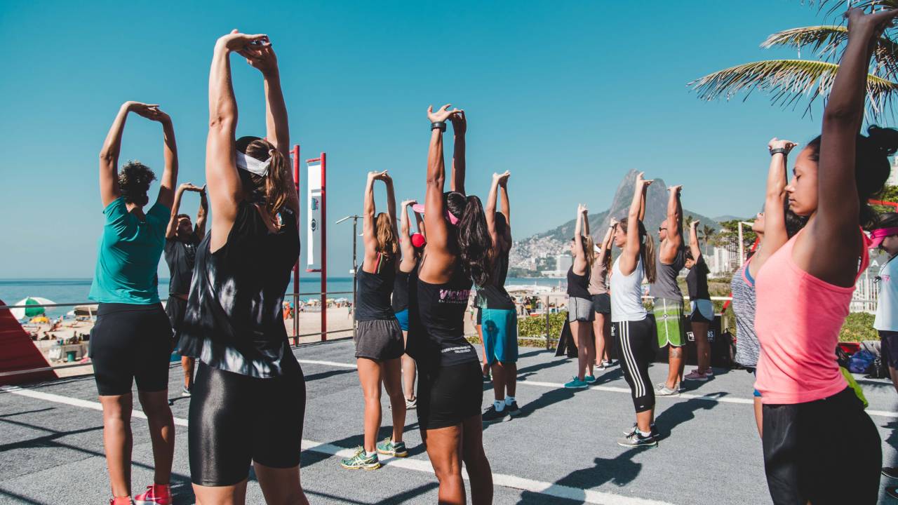 Foto mostra pessoas se exercitando na praia de Ipanema