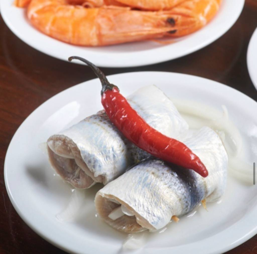rollmop adega Foto mostra rolinhos de sardinha com uma pimenta em cima