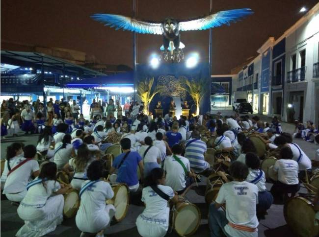águia quadra Portela Foto dos inegrantes da bateria ajoelhados em frente a águia da quadra da Portela