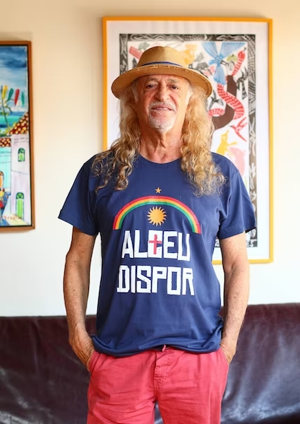 alceu-dispor Alceu Valença usa camiseta azul, com os símbolos da bandeira de Pernambuco, onde se lê: Alceu Dispor. Ele usa chapéu claro.