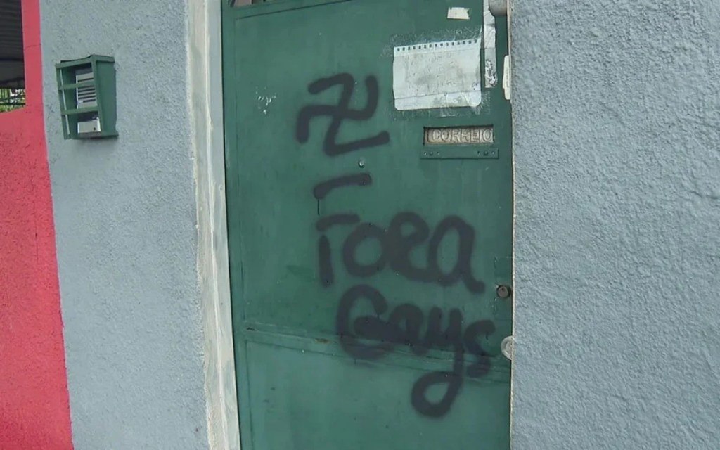 Casal gay tem portão pichado com símbolo nazista e frase homofóbica