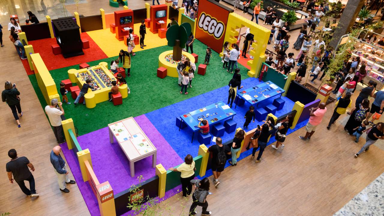 Foto mostra crianças brincando em espaço colorido com a temática Lego