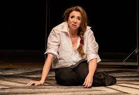A atriz Marisa Orth sentada no chão em cena da peça "Bárbara".