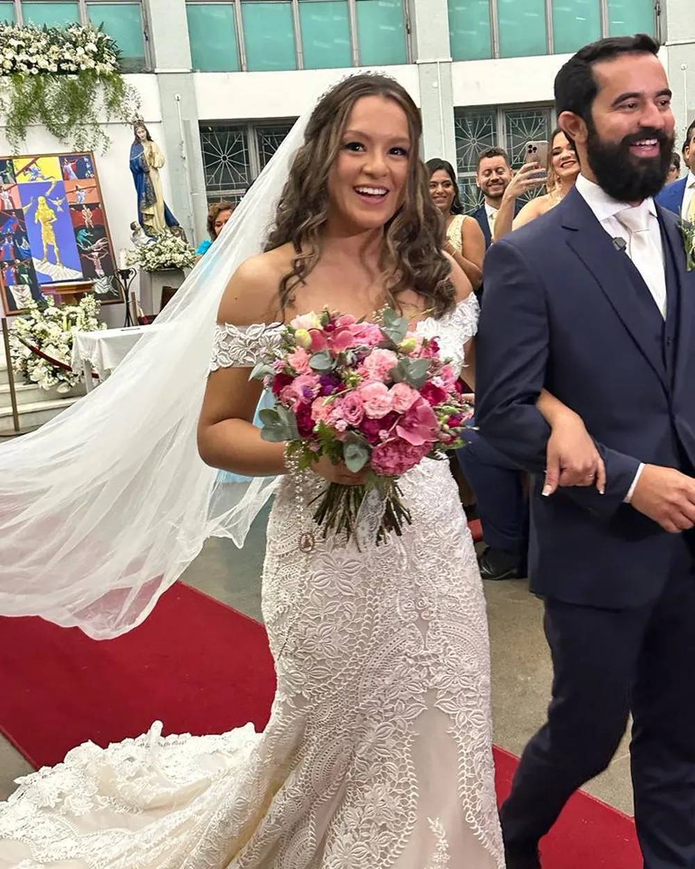 Foto mostra noivos se casando em igreja.