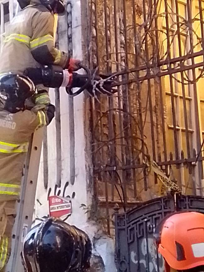 Bombeiros tentando usar a mangueira do portão
