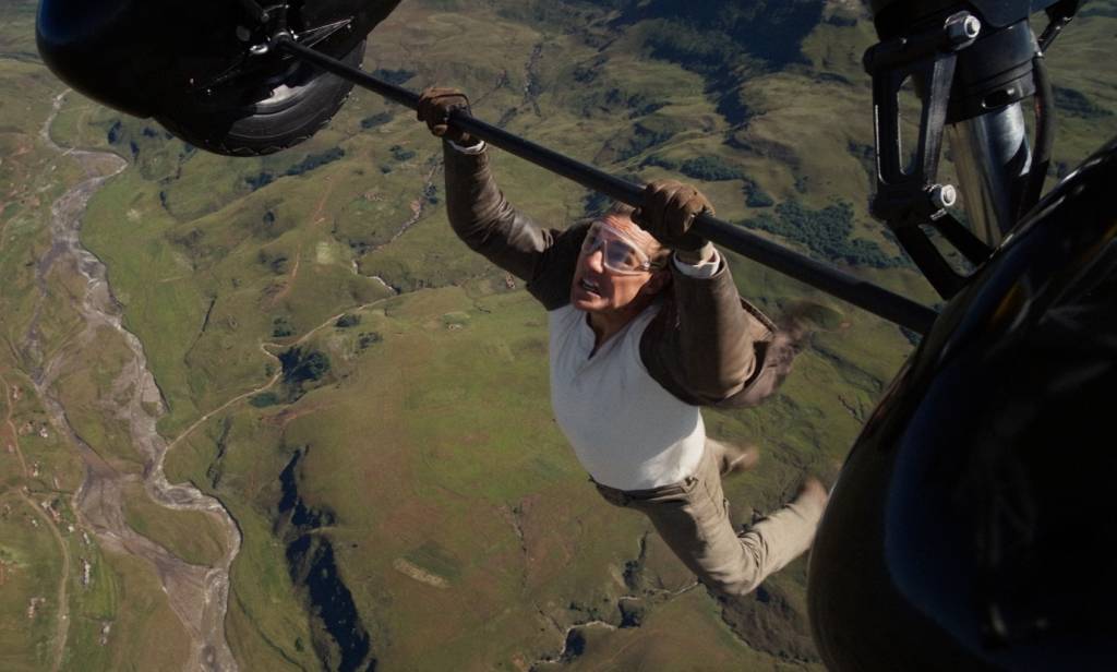 Ele não para! Tom Cruise aparece pendurado em avião