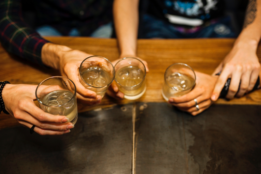 Copos com bebida alcoólica brindam.