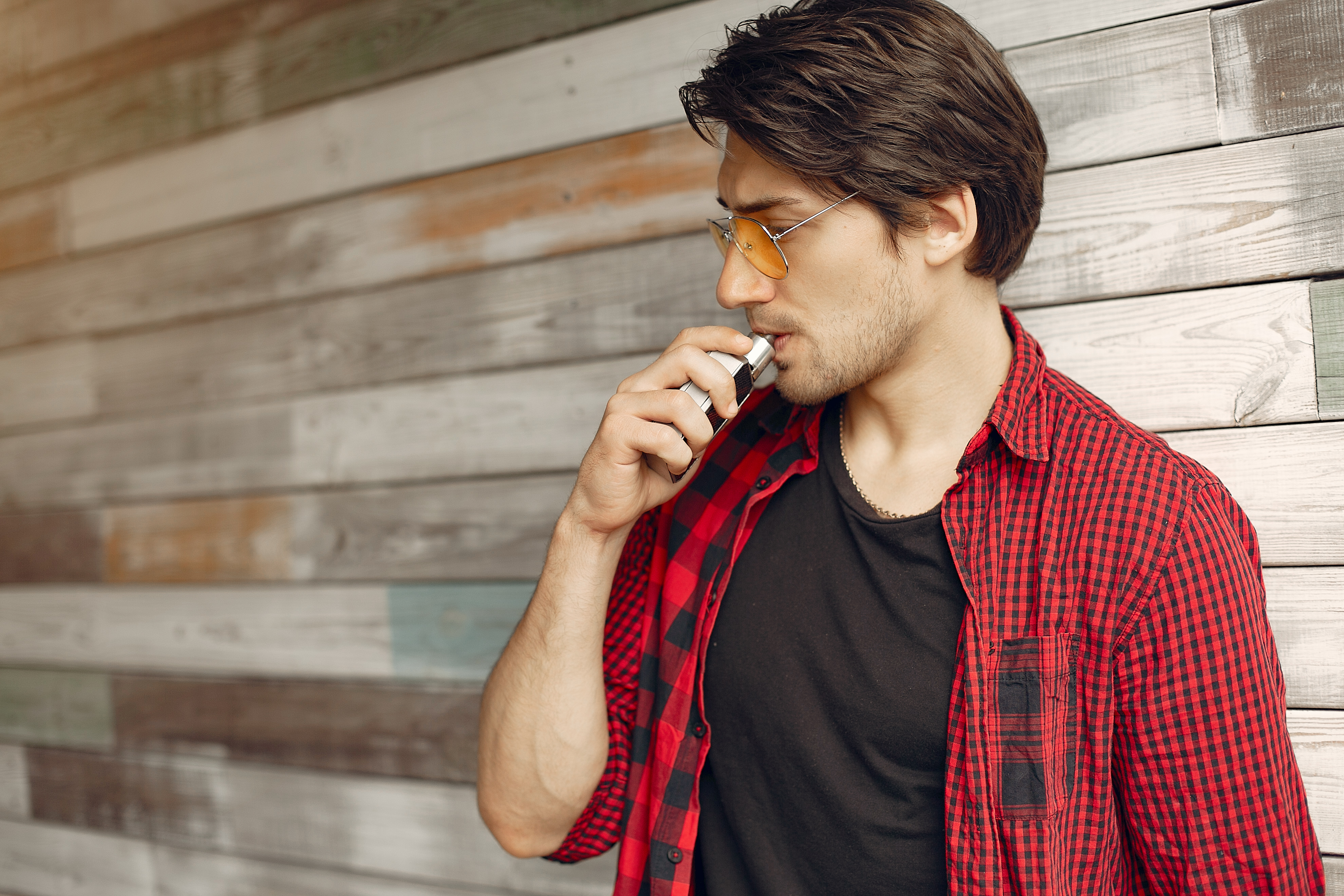 Stylish and elegant man in a city with vape