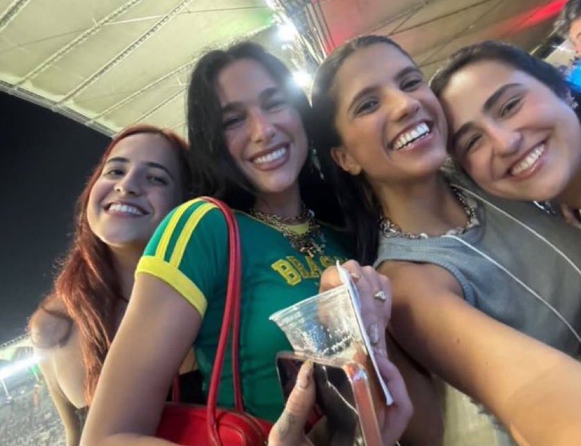 Dua Lipa com um copo de chope na m&atilde;o tirando foto com f&atilde;s