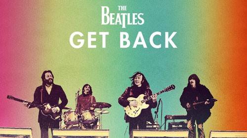 Os Beatles, Paul McCartney, Ringo Starr, John Lennon e George Harrison, tocando em um palco com fundo colorido em tons de verde, rosa e laranja. O t&iacute;tulo The Beatles Get Back aparece em branco no topo