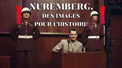 Homem de meia-idade em palet&oacute; cinza sentado em um p&uacute;lpito de madeira, com microfone. Dois soldados de uniforme militar marrom e capacete branco est&atilde;o de p&eacute; atr&aacute;s dele. O texto NUREMBERG, DES IMAGES POUR LHISTOIRE aparece em branco no topo